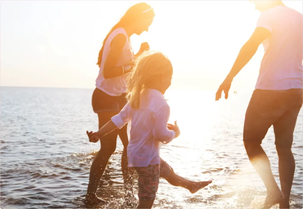 family having fun on a beach during sunset